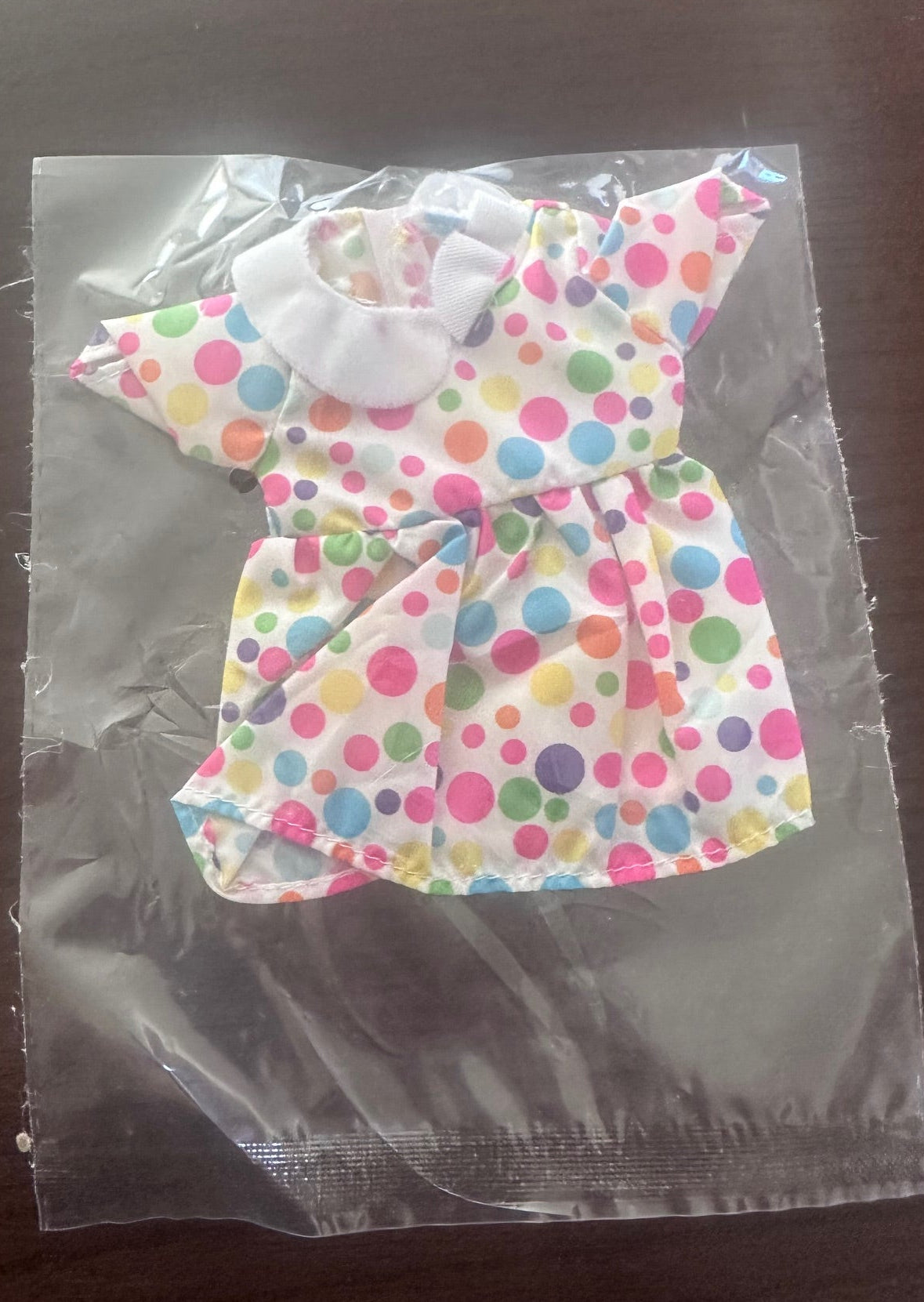 Colorful polka dot bow on a clear plastic bag with a dark background