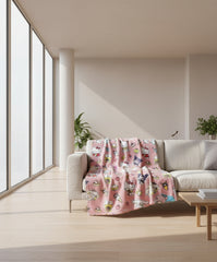 Pink blanket with cartoon character pattern on a couch hanging over the back
