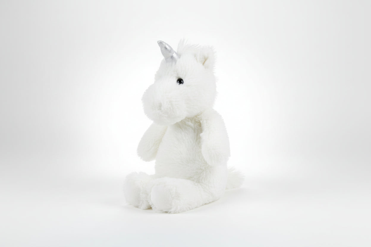 White plush unicorn toy with a silver horn on a white background