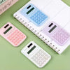 Mini Portable Calculators displayed on a desk in pink, blue, purple and white