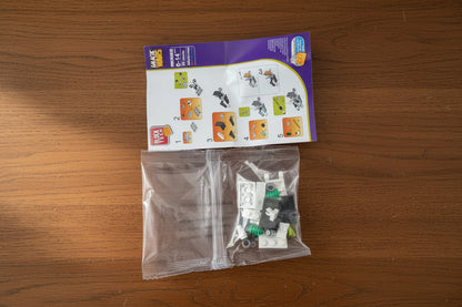 Unopened toy packaging with a purple leaflet on a wooden surface