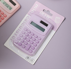 Mini portable purple calculator in packaging with dual power and clear display, ideal for school and office use.