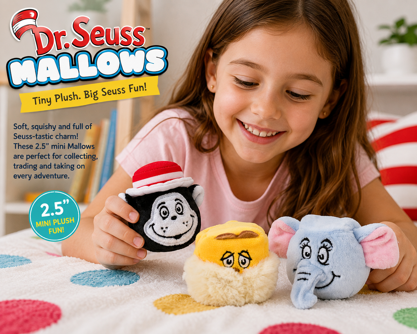 A young girl smiling while holding a Dr. Seuss Mallows mini plush charm shaped like a cat in a black and white hat, with two more plush charms—a yellow coffee cup and a light blue elephant—on a colorful blanket.