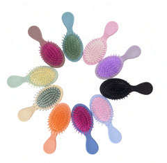 Colorful hairbrushes arranged in a circle on a wooden surface