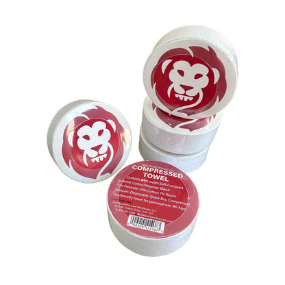 Stack of compressed towels with a red and white design on a white background
