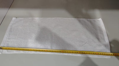 White fabric with a yellow measuring tape on a gray surface