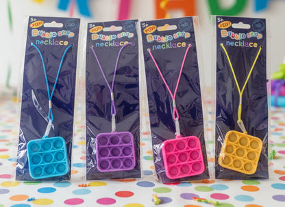 4ea Bubble Snap fidgette necklaces in package on a birthday party table