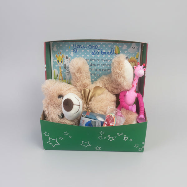 Plush toy with googly eyes inside a box on a wooden surface